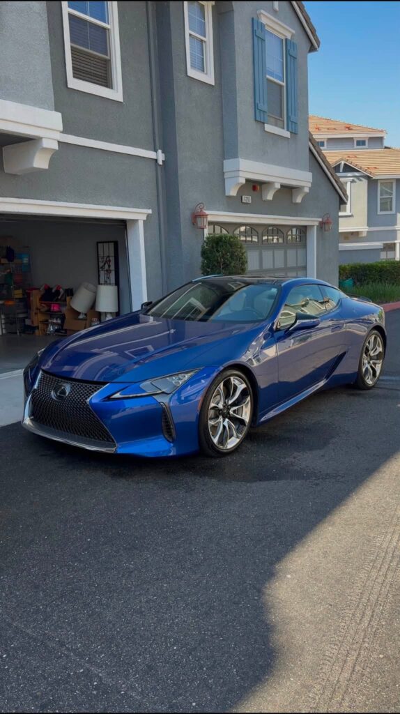 Blue Lexus coupe viewed from the front corner, showing its angular headlamp and grille