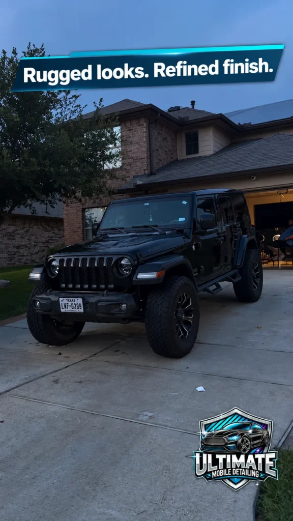 Black Jeep Wrangler on a driveway beneath a Rugged looks Refined finish banner and above the company logo