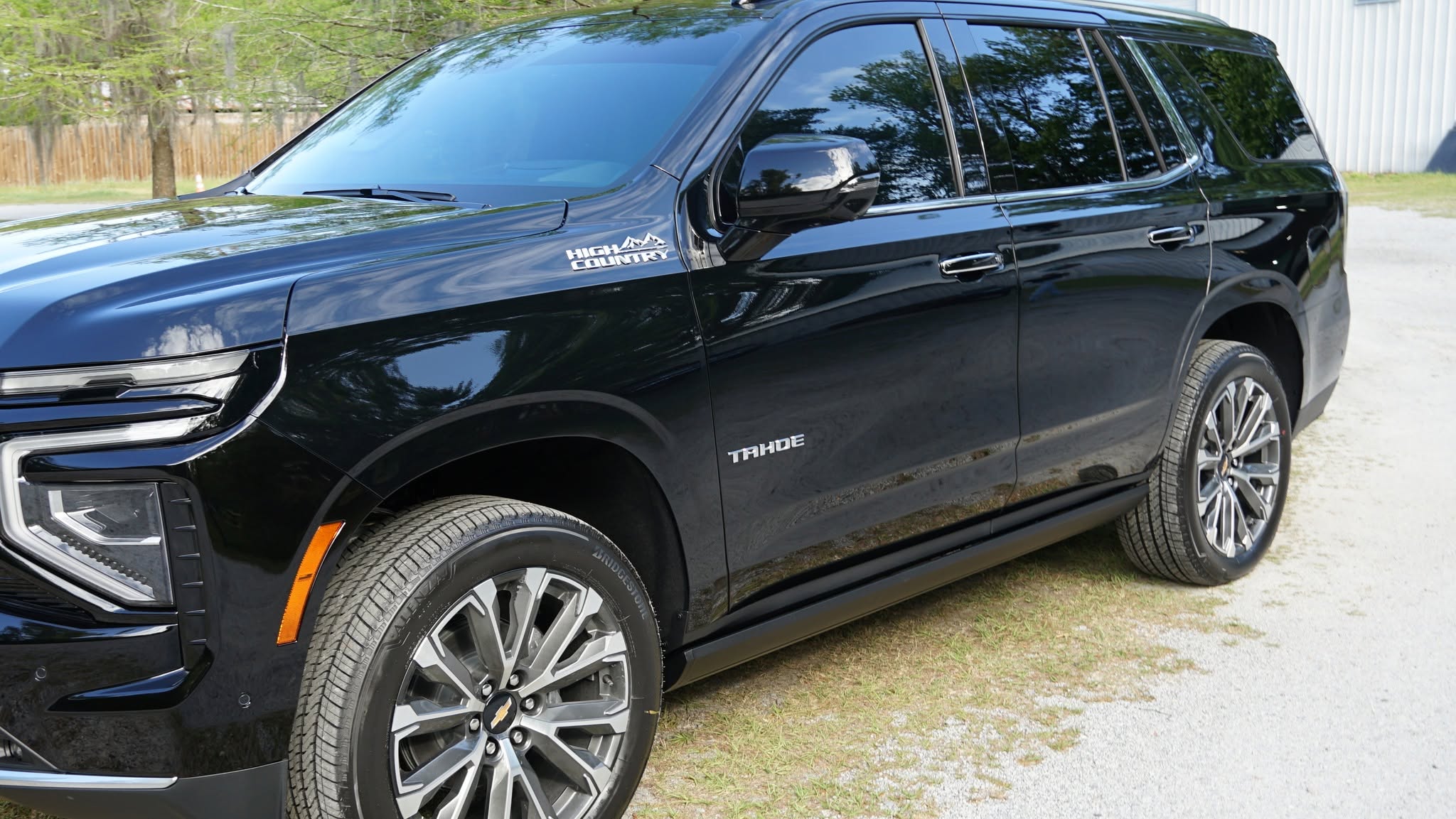 Black Chevrolet Tahoe showing reflective side panels, door trim and silver wheels