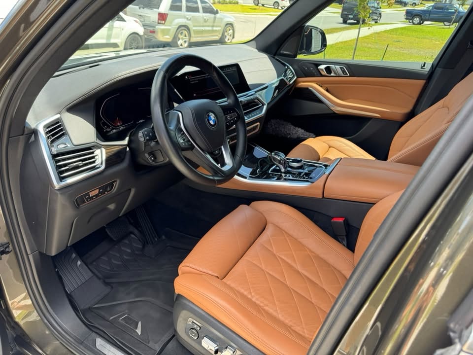 Tan leather front seats, black dashboard and center console in a BMW cabin