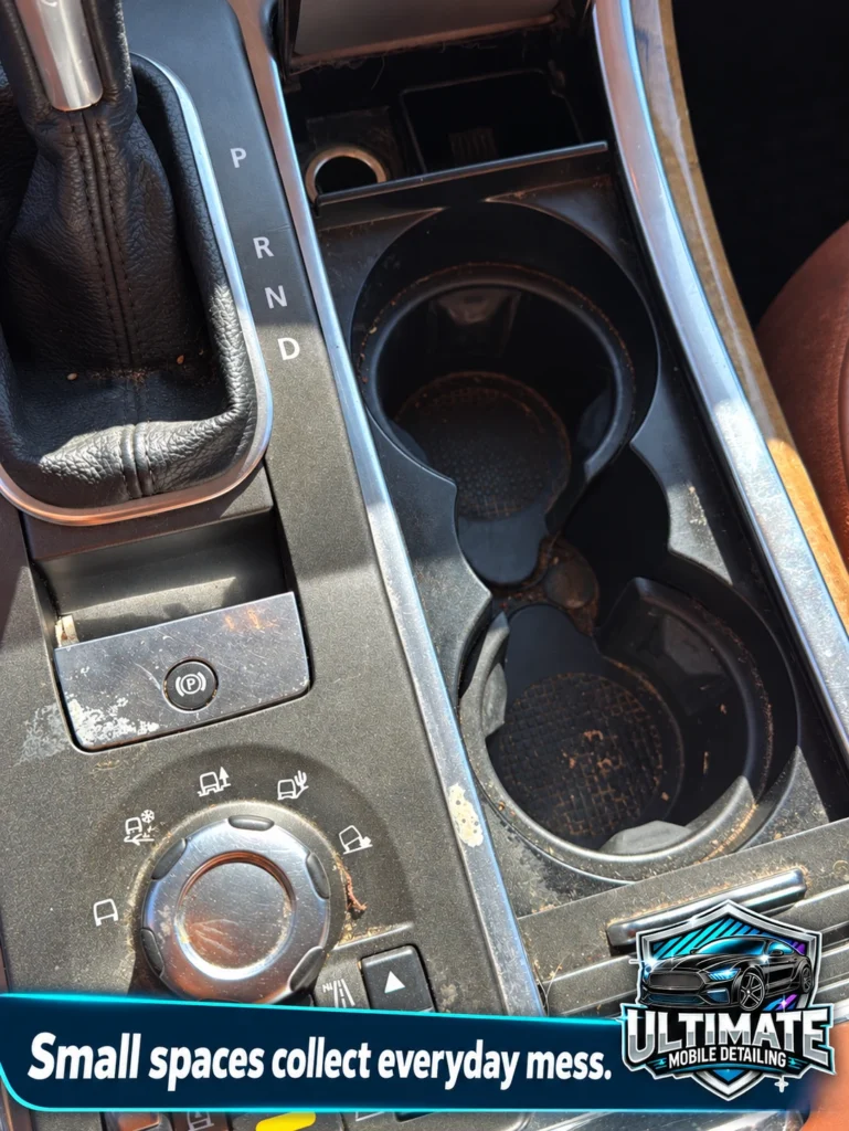 Dust and small debris around vehicle cupholders, gear selector and console controls