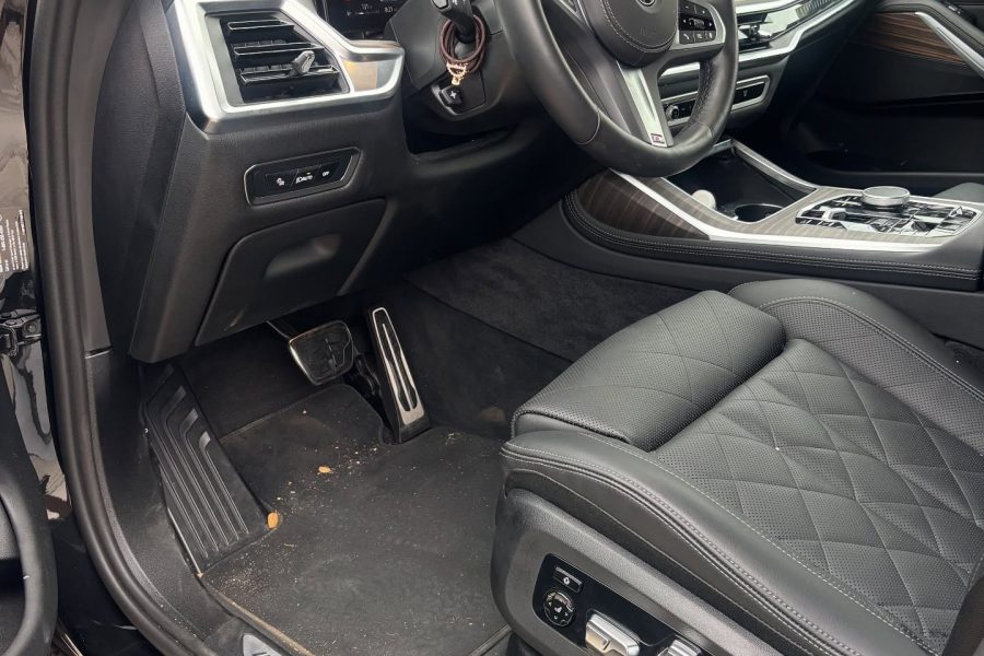 Vacuum nozzle removing crumbs from rear seat seams in Waialua, Hawaii